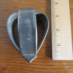 May include: A silver heart-shaped cookie cutter with the word "SPRITZ" embossed on the side.