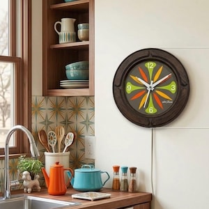 May include: A round wall clock with a dark brown wooden frame and a gray face featuring lime green and orange petal-shaped markers. The clock has white hour, minute, and second hands, with the numbers 3, 6, 9, and 12 displayed in lime green.