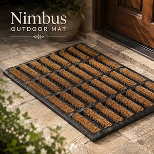 Può includere: Uno zerbino rettangolare con una cornice a griglia nera riempita di file di setole di cocco marroni. Il testo Nimbus OUTDOOR MAT è stampato in bianco sopra lo zerbino. Lo zerbino è posizionato su un pavimento in pietra vicino a un telaio di porta in legno.