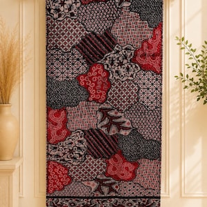 Könnte beinhalten: Ein rechteckiger Wandbehang aus Textil mit einem komplexen Patchwork-Design in Rot, Schwarz und Weiß. Der Stoff zeigt verschiedene geometrische, florale und abstrakte Muster in unregelmäßigen Formen, abgeschlossen mit einer dunklen Bordüre.