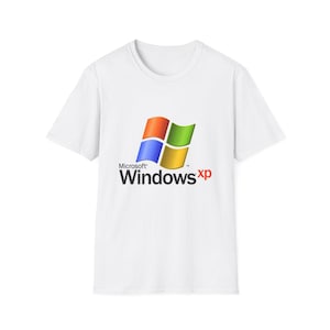 May include: A white short-sleeved t-shirt featuring the Microsoft Windows XP logo printed on the centre of the chest. The logo consists of a four-coloured flag graphic in red, green, blue, and yellow, with the text Microsoft Windows xp below.