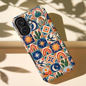 May include: A smartphone case featuring a grid of square tiles with colorful illustrations including suns, moons, stars, rainbows, cacti, swallows, and floral patterns in shades of blue, orange, green, and cream with a dual camera cutout.