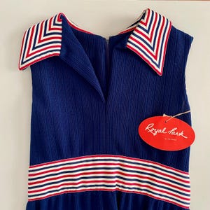 May include: A vintage navy blue dress with a collared neckline and a striped design in red, white, and blue. The dress features a zipper closure and a tag that reads "Royal Park".