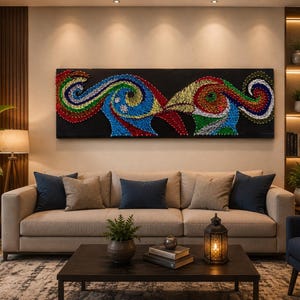 Könnte beinhalten: Ein rechteckiges Wandbild aus Fadenkunst, das zwei stilisierte vogelartige Figuren auf schwarzem Hintergrund zeigt. Das Kunstwerk verwendet lebendige, mehrfarbige Fäden in Rot-, Blau-, Grün- und Gelbtönen, die komplexe, wirbelnde Muster bilden.