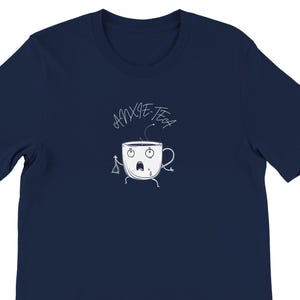 May include: A navy blue short-sleeved t-shirt featuring a white graphic of a cartoon teacup with a worried facial expression, thin arms and legs, and a tea bag string. The text ANXIE-TEA is printed in a handwritten style above the teacup.