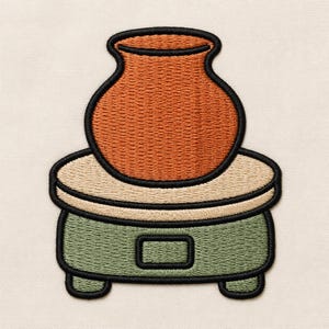 Puede incluir: Un parche bordado que muestra una vasija de barro color terracota sobre un torno de alfarero beige. La base del torno es de color verde salvia con un pequeño detalle rectangular, y todo el diseño está delineado con hilo negro grueso.