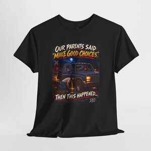 May include: A black short-sleeve t-shirt featuring a graphic print of a person kneeling by a blue pickup truck at night. The text reads: OUR PARENTS SAID "MAKE GOOD CHOICES" THEN THIS HAPPENED... with a small signature in the bottom right corner.