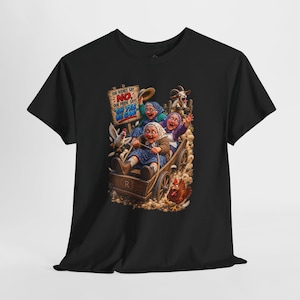 May include: A black t-shirt featuring a graphic of three elderly individuals riding in a wooden cart pulled by a goat. The text reads: OUR BODIES SAY NO, OUR PRIDE SAYS OH YES WE CAN! A chicken is visible near the cart, which has an R on the side.