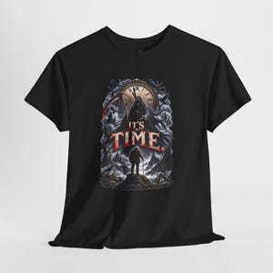 May include: A black short-sleeve t-shirt featuring a graphic print of a hooded figure with a scythe standing before a large clock. Below, a person stands on a rocky hill. The text IT'S TIME is printed in large, bold, distressed red and white letters.