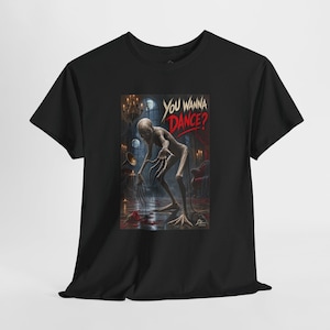 May include: A black short-sleeve t-shirt featuring a graphic print of a pale, thin, long-fingered creature in a dark room with a chandelier and candles. The text "YOU WANNA DANCE?" is printed in white and red above the creature on the front of the shirt.
