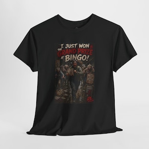 May include: A black short-sleeve t-shirt featuring a graphic print of a person running through a crowd. The text reads I JUST WON THE GRAND PRIZE AT BINGO! along with smaller text including THAT BITCH HAD B-12 and BINGO TONIGHT. The design is dark.