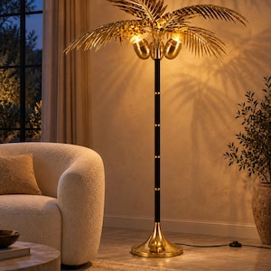 Pode incluir: Um candeeiro de pé em forma de palmeira com uma copa de folhas em metal dourado, duas lâmpadas integradas, um poste preto alto e fino com detalhes dourados e uma base circular larga e polida em tom dourado.