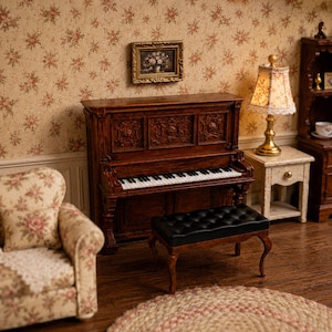 May include: A miniature upright piano made of dark brown wood with intricate carved panels, featuring a black and white keyboard. A matching black tufted bench with curved legs sits in front of the piano, completing this detailed dollhouse furniture set.