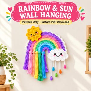 Könnte beinhalten: Ein gehäkelter Wandbehang mit einem Regenbogen, einer gelben Sonne und einer weißen Wolke. Der Regenbogen hat Quasten aus violetter, blauer, grüner, gelber, oranger und rosa Wolle. Die weiße Wolke hat kleine hängende Regentropfen in verschiedenen Farben.