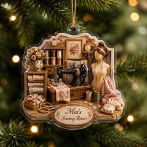 May include: A decorative acrylic ornament featuring a detailed sewing room scene with a vintage black sewing machine, a dress form, spools of thread, lace, and a basket. An oval plaque at the bottom displays the text Mia's Sewing Room.