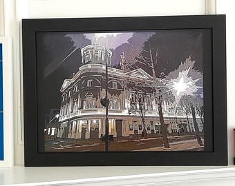 May include: A framed art print of the Coronet Theatre in a stylized illustration. The black frame surrounds the image of the building with the text "CORONET" visible. The artwork features a dark color palette with a bright light source.