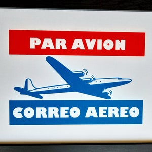 Può includere: Un poster in stile vintage con uno schema di colori rosso e blu. Il poster presenta un aereo blu con il testo "PAR AVION" in rosso e "CORREO AEREO" in blu.