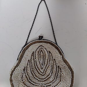 Cartera estilo flapper de color marfil con asa superior con cierre de beso y cuentas