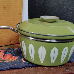 May include: A green enamel saucepan with a white leaf pattern and a matching lid. The saucepan has a silver handle.