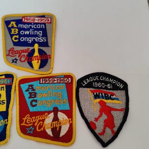 May include: A collection of vintage bowling patches. The patches feature text such as "American Bowling Congress" and "League Champion" with years like 1958-1959, 1959-1960, and 1960-1961. The patches are in various colors.