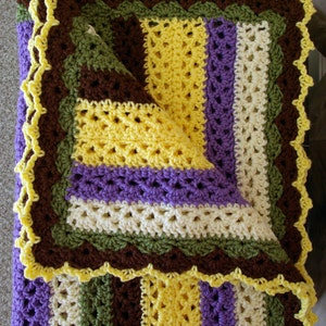 May include: A crocheted blanket with a scalloped border in brown, green, yellow, and purple stripes.