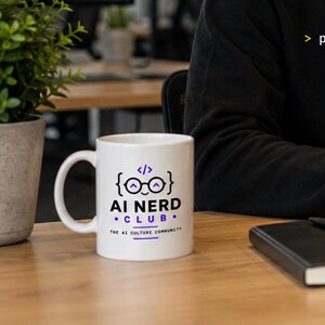Könnte beinhalten: Ein weißer Keramikbecher mit einer Grafik eines lächelnden Gesichts mit Brille innerhalb von geschweiften Klammern und Code-Tags. Der Text lautet AI NERD CLUB und THE AI CULTURE COMMUNITY in schwarzer und violetter Schrift mit horizontalen Linien.