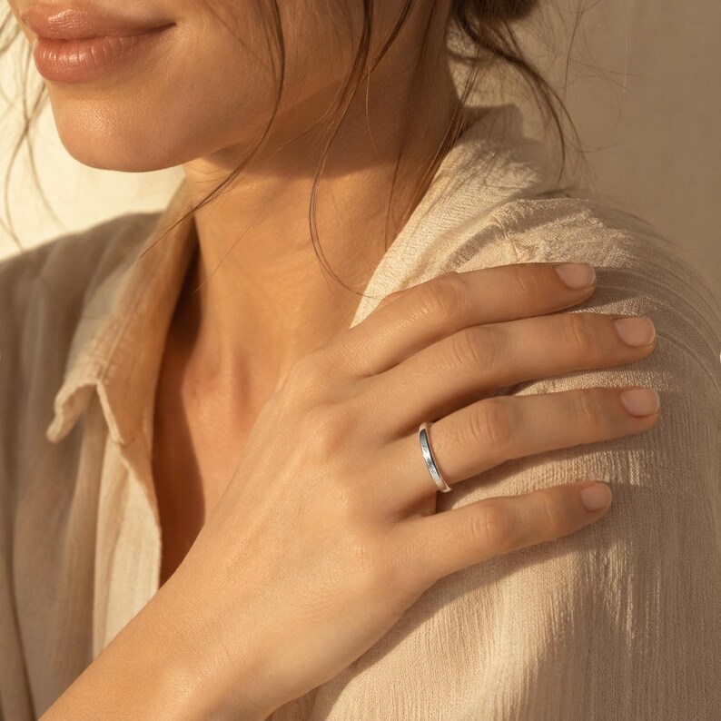 Woman wearing a sterling silver engraved name ring on her finger