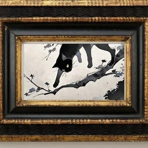 May include: A framed art print featuring a black cat walking along a tree branch with small flowers. The artwork is set within a rectangular frame that has a textured black inner border and a decorative gold outer border with wavy patterns.