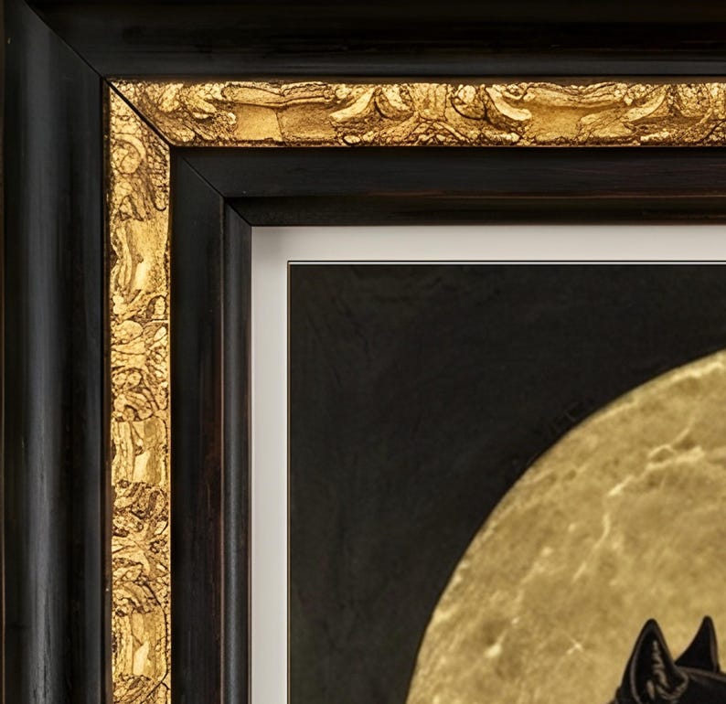May include: A framed artwork featuring a black and gold color palette. The frame has a smooth black outer edge and an ornate, textured gold inner border. Inside, a white mat surrounds a dark background with a large, circular gold element.