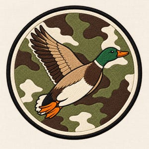 May include: A circular embroidered patch featuring a mallard duck in flight against a camouflage background of green, brown, and cream. The duck has a green head, orange beak, and brown and white wings. The patch has a thick black border.