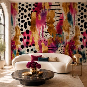 May include: A curved white sofa with a dark marble coffee table and a wall mural featuring abstract splashes of gold, magenta, and teal paint, accented by black polka dots and horizontal lines, creating a bold, layered, and textured visual effect.