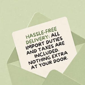 May include: A light green envelope containing a white card with the text: HASSLE-FREE DELIVERY: ALL IMPORT DUTIES AND TAXES ARE INCLUDED. NOTHING EXTRA AT YOUR DOOR. The text is printed in a dark green, sans-serif font on the card surface.