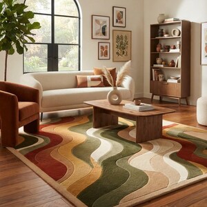 May include: A rectangular area rug featuring a repeating pattern of undulating, wave-like stripes in shades of olive green, burnt orange, mustard yellow, and cream. The rug has a textured, tufted pile surface and is positioned on a wooden floor.