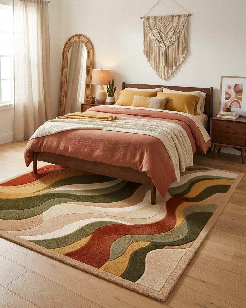 May include: A rectangular area rug featuring a wavy, multi-colored pattern in shades of terracotta, olive green, mustard yellow, and cream. The rug has a textured, tufted surface with a thick border and is positioned under a wooden bed frame.