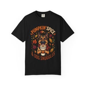 Könnte beinhalten: Ein schwarzes T-Shirt mit einer Grafik eines Deutschen Schäferhundes, der einen roten Schal trägt und einen Kaffeebecher hält. Das Design zeigt Herbstblätter, Eicheln und den Text PUMPKIN SPICE & DOG SNUGGLES in orange und weiß.