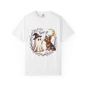Könnte beinhalten: Ein weißes Kurzarm-T-Shirt mit einer Grafik eines Geistes mit Hexenhut, der die Nase eines Yorkshire Terriers berührt. Das Design zeigt zudem eine Mondsichel, Fledermäuse und einen Kranz aus Herbstblättern mit dem Schriftzug "boo-p".