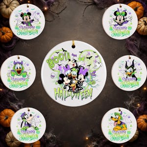 May include: A collection of seven round white ceramic ornaments featuring Disney characters in Halloween costumes. The central ornament displays a group of characters with the text BOO! HALLOWEEN, while the six surrounding ornaments show individual characters with the text HAPPY HALLOWEEN, spiderwebs, and pumpkins.