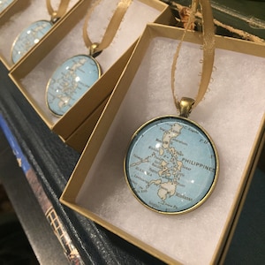 May include: Four gold-colored ornament boxes with blue and white map ornaments inside. The ornaments feature a map of the Philippines with the text "PHILIPPINES" and the names of various cities and islands.
