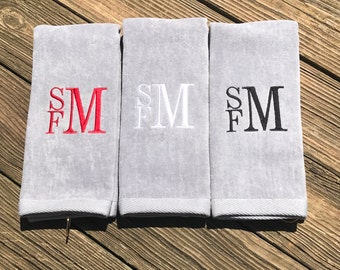 May include: Three gray towels with embroidered initials "SFM" in red, white, and black.