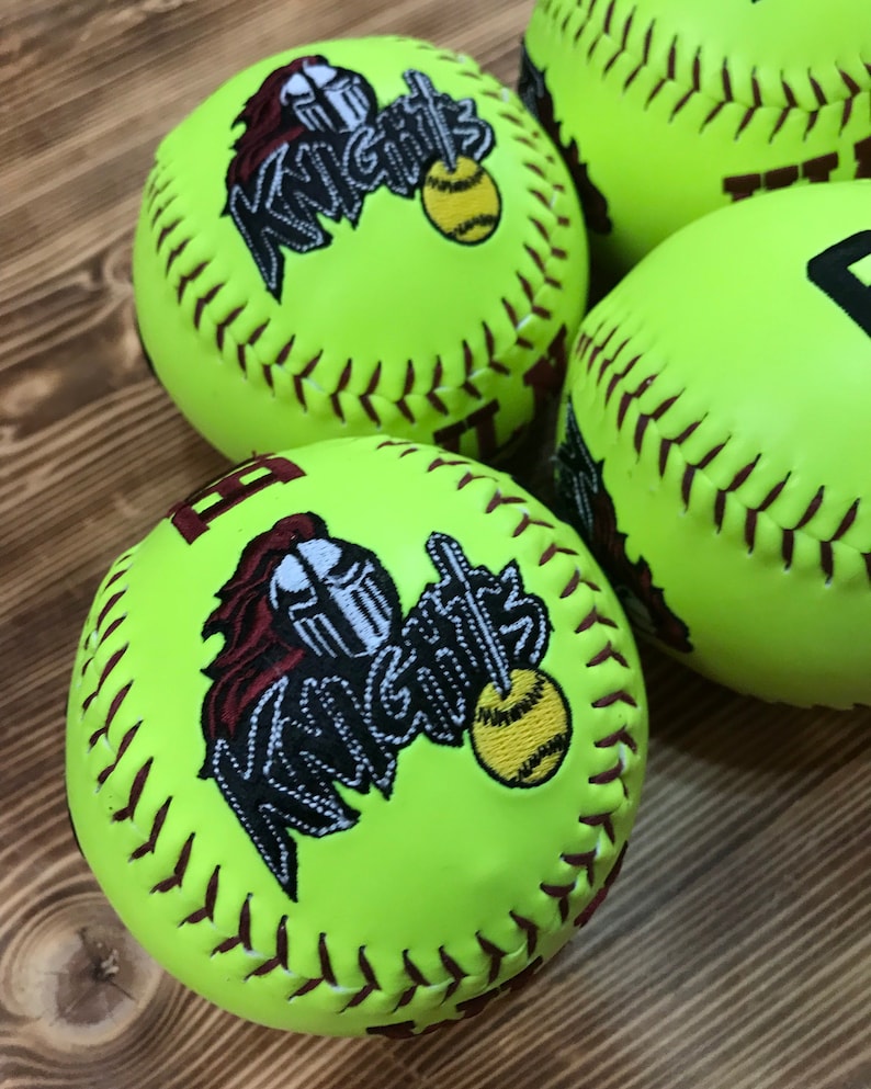 May include: Four yellow softball with brown stitching. Each ball has a maroon and white embroidered logo that says "Knights" with a knight's helmet and a smaller softball.