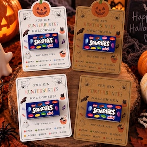 Puede incluir: Cuatro tarjetas rectangulares con una caja de caramelos Smarties mini fijada en el centro. Las tarjetas muestran gráficos de Halloween que incluyen calabazas, fantasmas, murciélagos y telarañas, con el texto FÜR EIN KUNTERBUNTES HALLOWEEN.