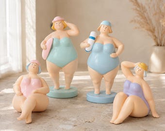 May include: Four resin figurines of people in swimsuits. One sits in a pink swimsuit, one stands in a mint green swimsuit with a pink towel, one stands in a light blue swimsuit holding a white and blue tube, and one sits in a lavender swimsuit.