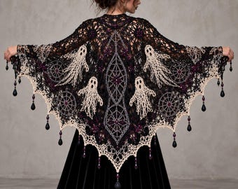 May include: A black and cream crocheted shawl featuring intricate ghost motifs, spiderweb patterns, and dark purple bead accents. The triangular garment has a scalloped edge finished with dangling black teardrop beads along the entire bottom hem.