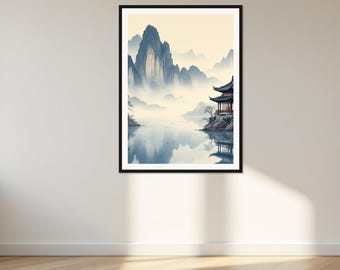 Op de afbeelding: Een ingelijste wandkunstprint met een landschapsillustratie van een traditionele pagodestructuur op een rotsachtige oever naast een kalm wateroppervlak, met hoge, mistige, blauwgetinte bergtoppen op de achtergrond.