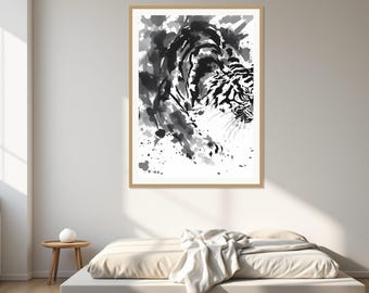 Puede incluir: Una impresión de arte mural enmarcada que presenta una ilustración en blanco y negro de un tigre al estilo de aguada. La obra utiliza pinceladas expresivas y salpicaduras para representar la forma del tigre sobre un fondo blanco en un marco de madera clara.