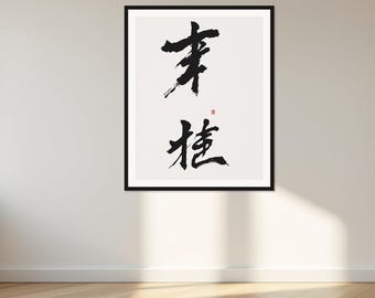 Puede incluir: Una pieza de arte mural enmarcada con caligrafía en tinta negra sobre fondo blanco. La obra muestra dos caracteres chinos distintos escritos con un estilo de pincelada audaz y expresivo, acompañados por un pequeño sello rojo.