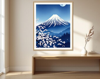 May include: A framed wall art print featuring a blue-toned landscape of Mount Fuji with a snow-capped peak under a night sky with a crescent moon. In the foreground, a dark tree branch is covered in white cherry blossoms against the blue mountain.