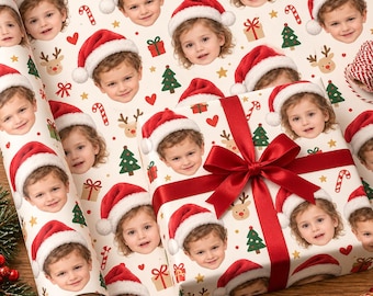 Può includere: Carta da regalo personalizzata con un motivo ripetuto del volto di un bambino che indossa un cappello da Babbo Natale rosso e bianco, intervallato da piccole illustrazioni di alberi di Natale, renne, regali, cuori e bastoncini di zucchero.