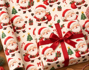 Può includere: Un rotolo e una scatola di carta da regalo con un motivo ripetuto di Babbo Natale, alberi di Natale verdi, pacchetti regalo rossi e bastoncini di zucchero su sfondo crema. La scatola è legata con un ampio nastro di raso rosso scuro.