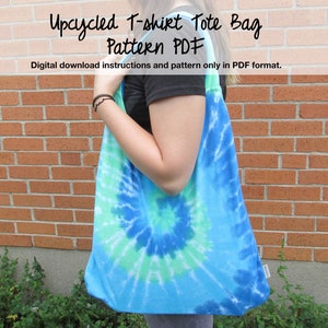 Puede incluir: Una bolsa de mano de color azul y verde tie-dye hecha de una camiseta reciclada. La bolsa de mano está siendo sostenida por una persona. El texto "Upcycled T-shirt Tote Bag Pattern PDF" está en la parte superior de la imagen. El texto "Digital download instructions and pattern only in PDF format." está debajo del título.